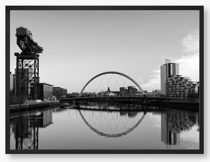 Black and White framed photograph of Glasgow's River Clyde with reflections, including a prominent crane and modern cityscape in the background.