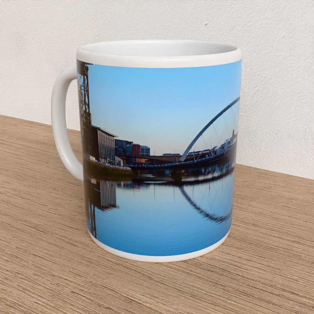 Mug with a scenic design of a bridge and water on a wooden surface