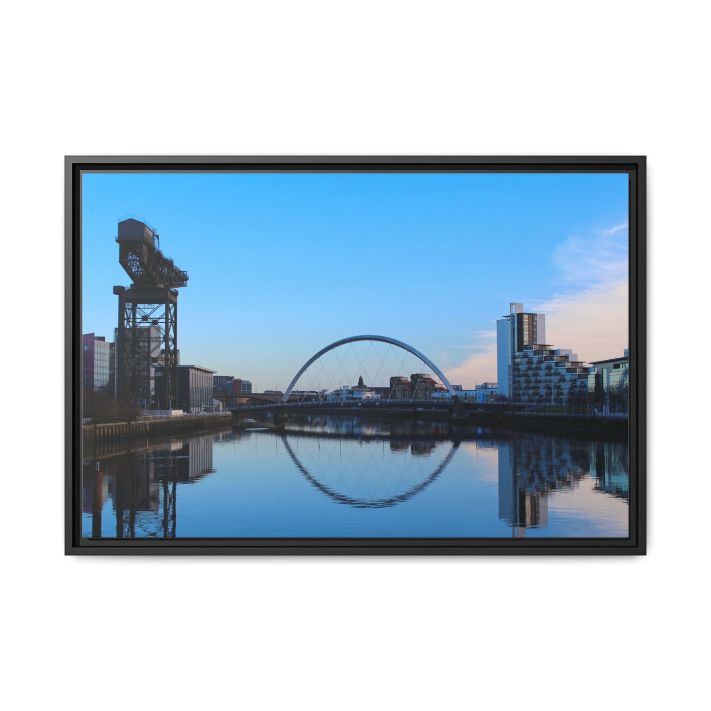 Framed photograph of a cityscape with a crane and arch reflection in water