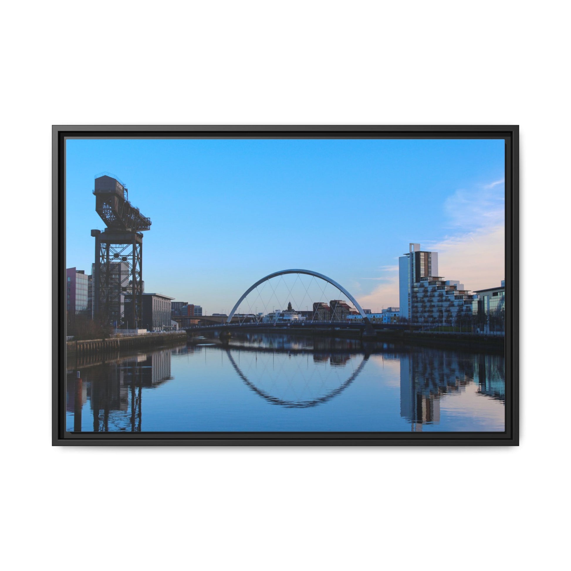 Framed photograph of a cityscape with a crane and arch reflection in water