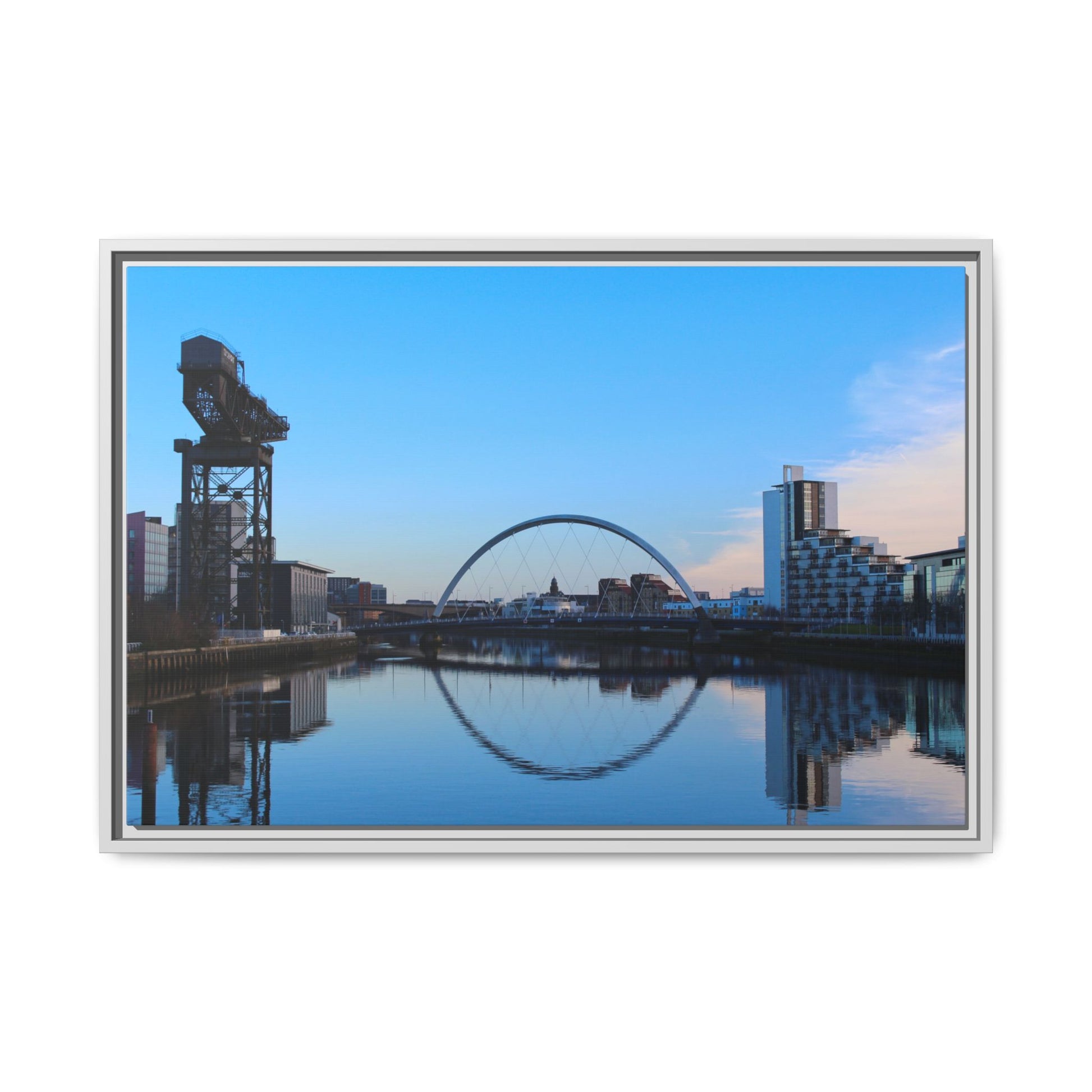 Cityscape with a crane and arch reflected in water, framed as a photograph.