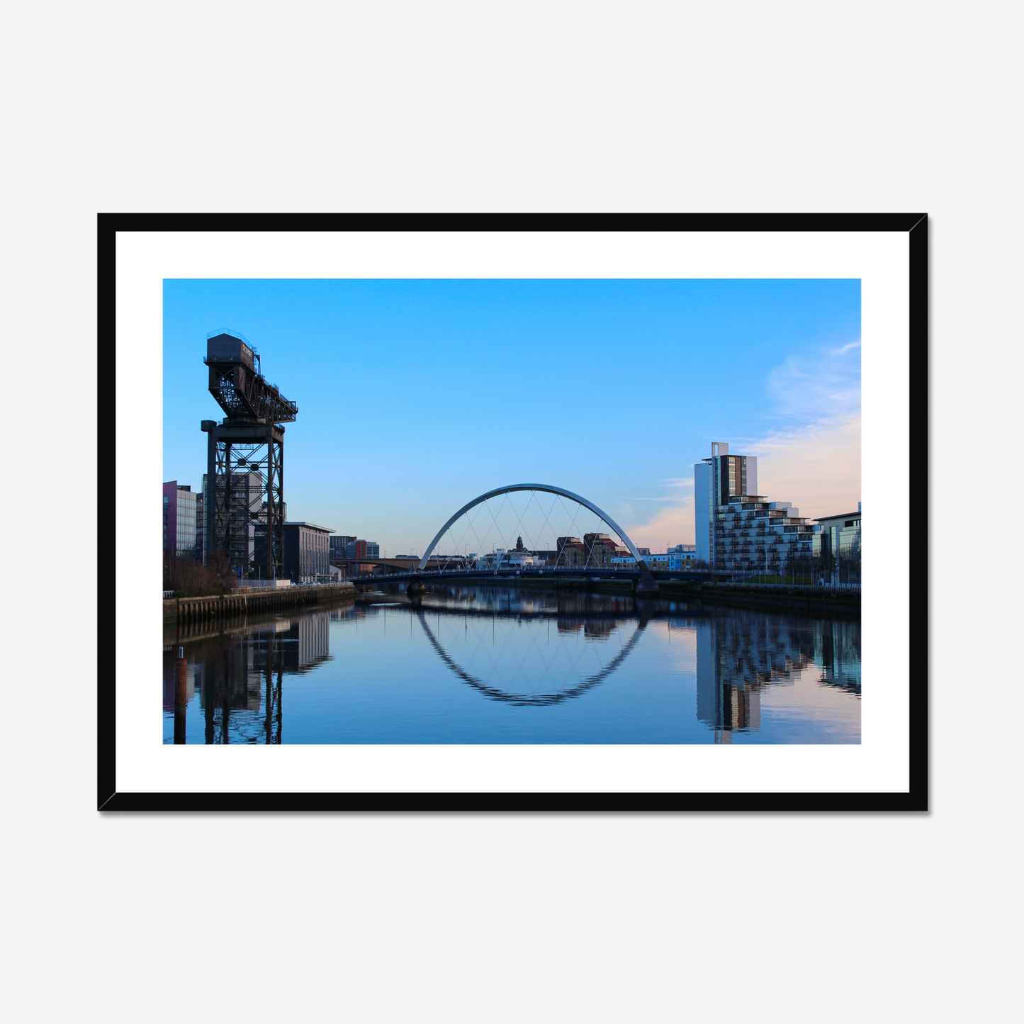 Framed photograph of a cityscape with a bridge and skyline reflected in water.