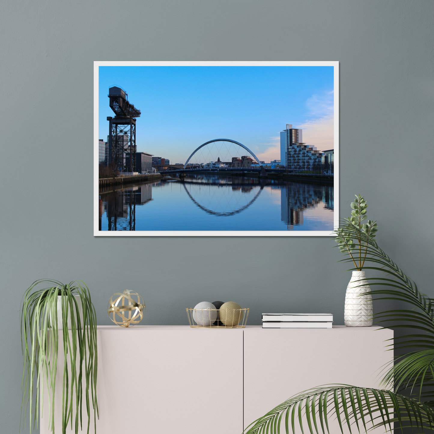 Framed cityscape print on a wall with decorative items below
