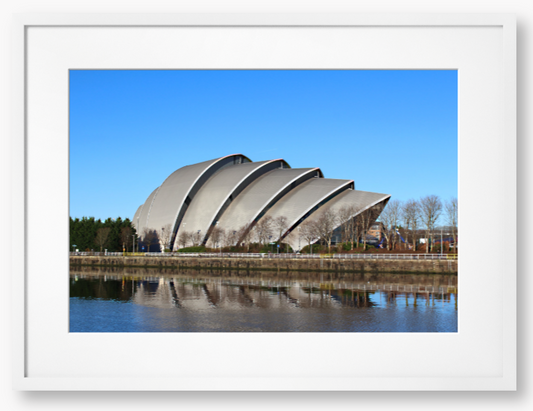 Framed Photo of a Modern architectural building reflected in water with a clear blue sky