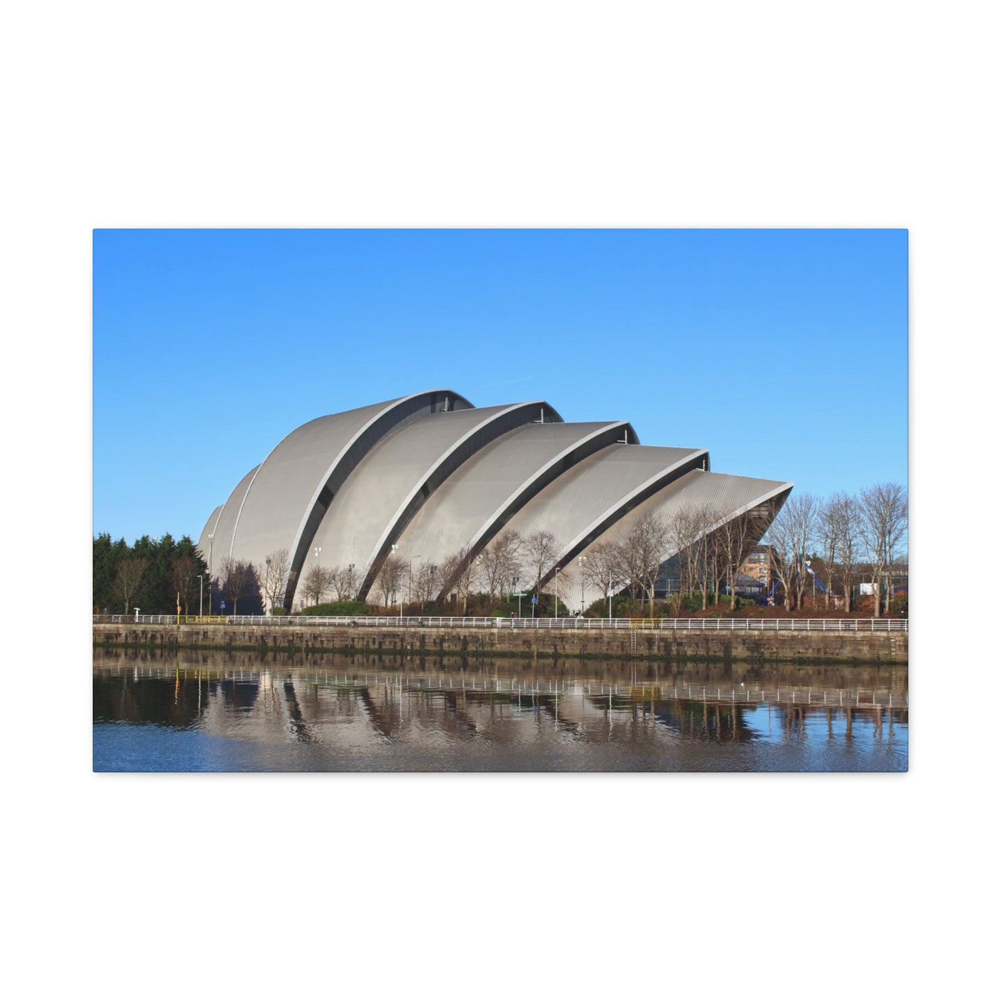 Modern architectural structure with curved design by a body of water on a clear day.