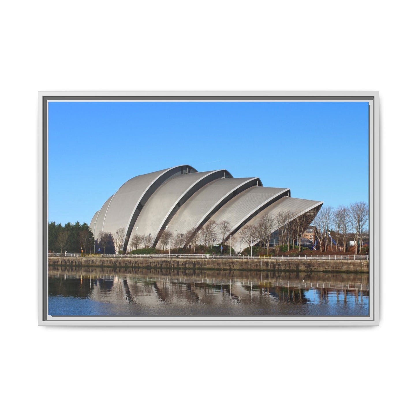 Modern architectural building with curved design by a body of water on a clear day.