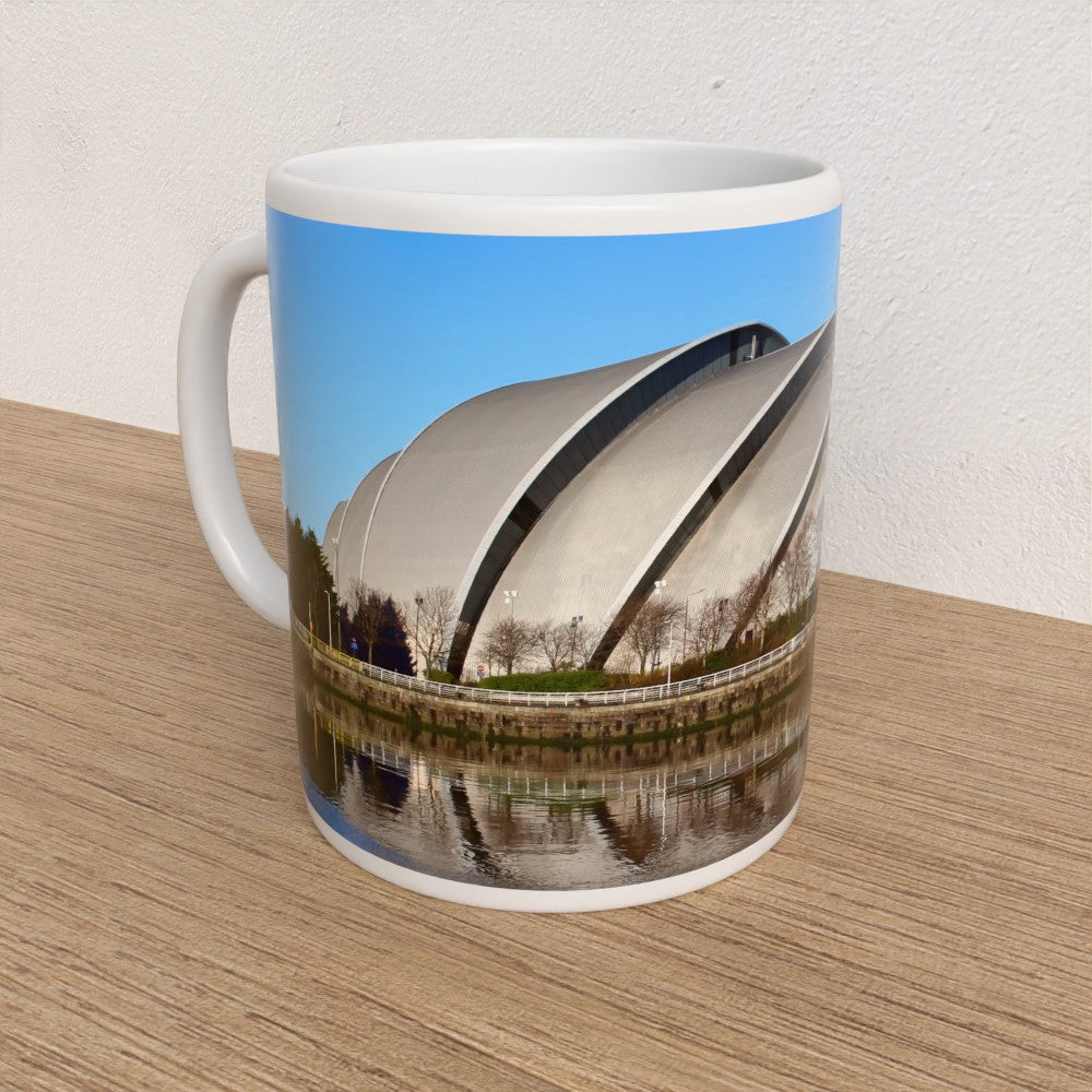 Mug with a printed design of a modern building on a wooden surface