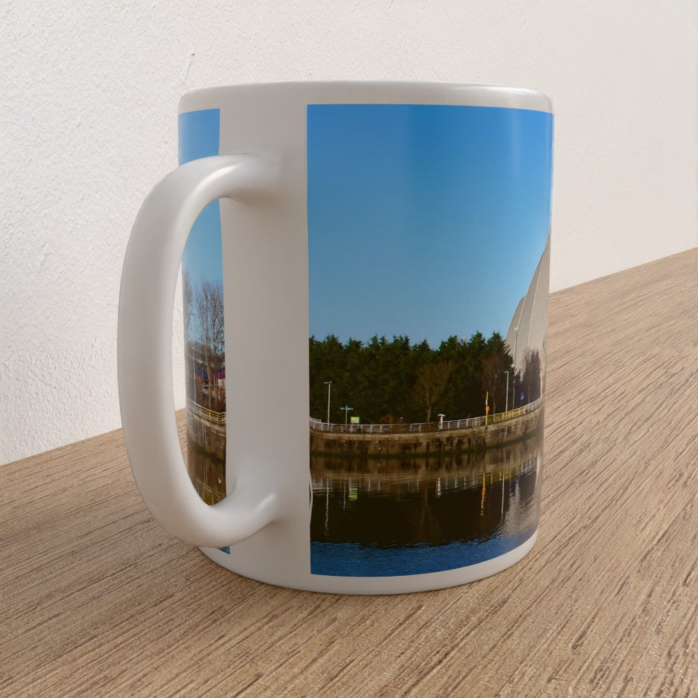 Mug with a scenic design of a river and trees on a wooden surface