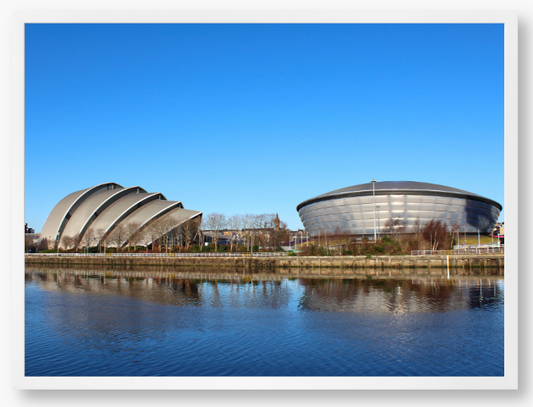 Framed Photo of Modern architectural buildings reflected in water with a clear blue sky