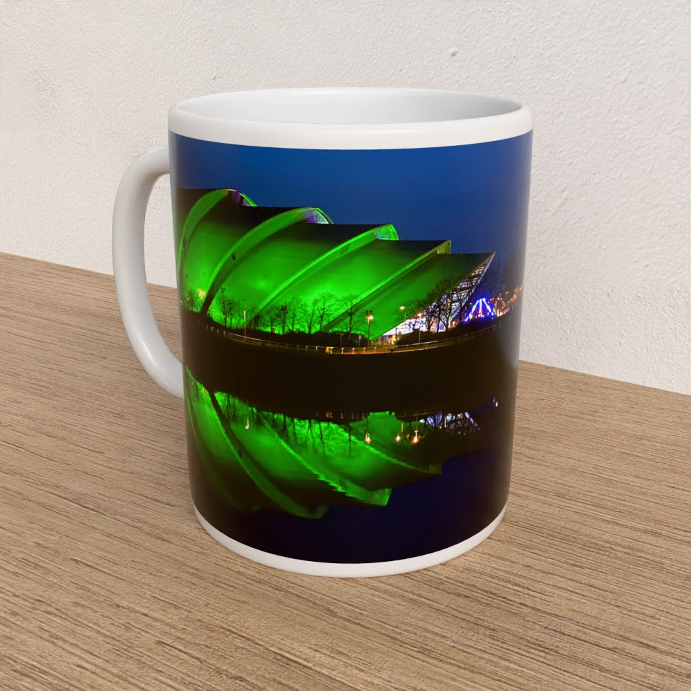 Mug with a green and blue design on a wooden surface