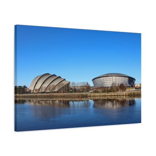 Modern architectural structures reflected in water with a clear blue sky
