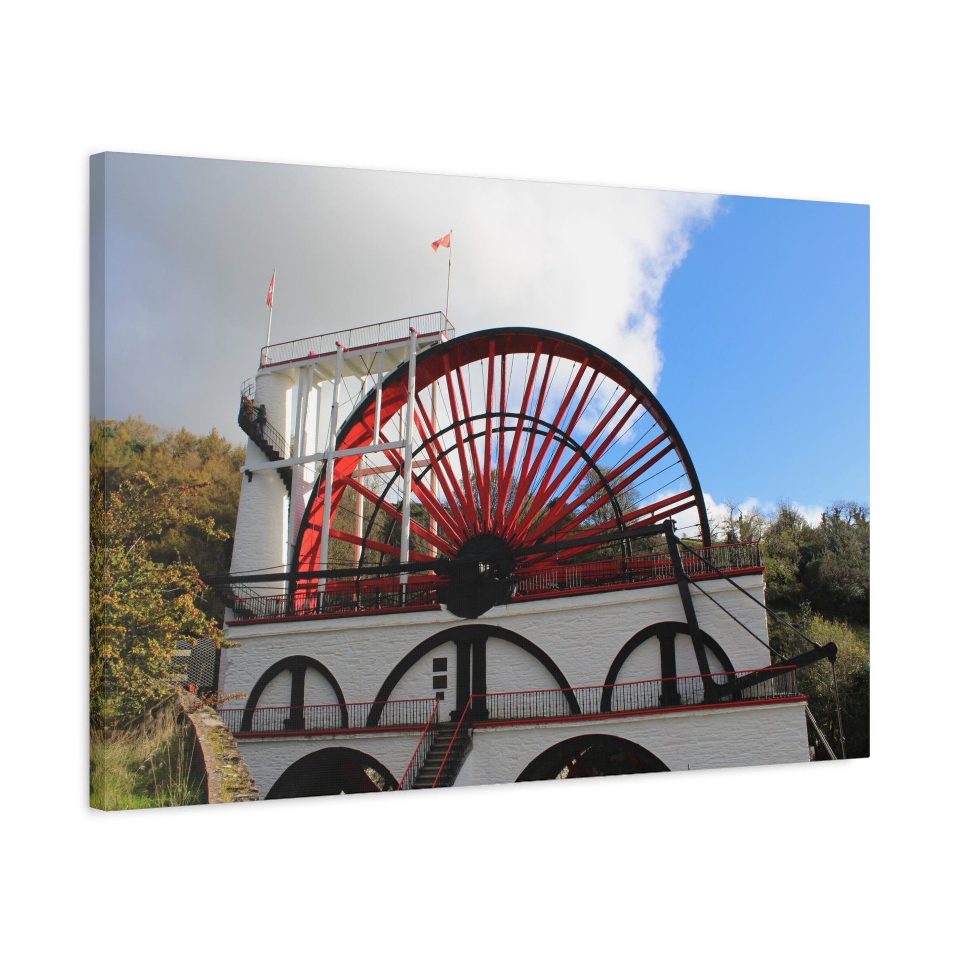 Canvas print of a large water wheel with a blue sky background