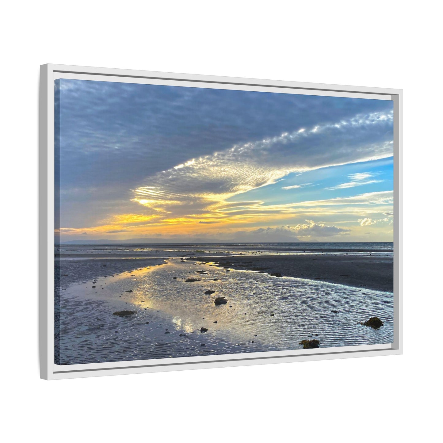 Framed artwork of a sunset over a landscape with a white frame.
