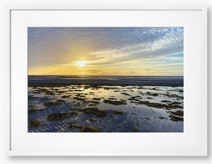 Framed Photo Of A Sunset over a coastal landscape with wet sand and low tide.