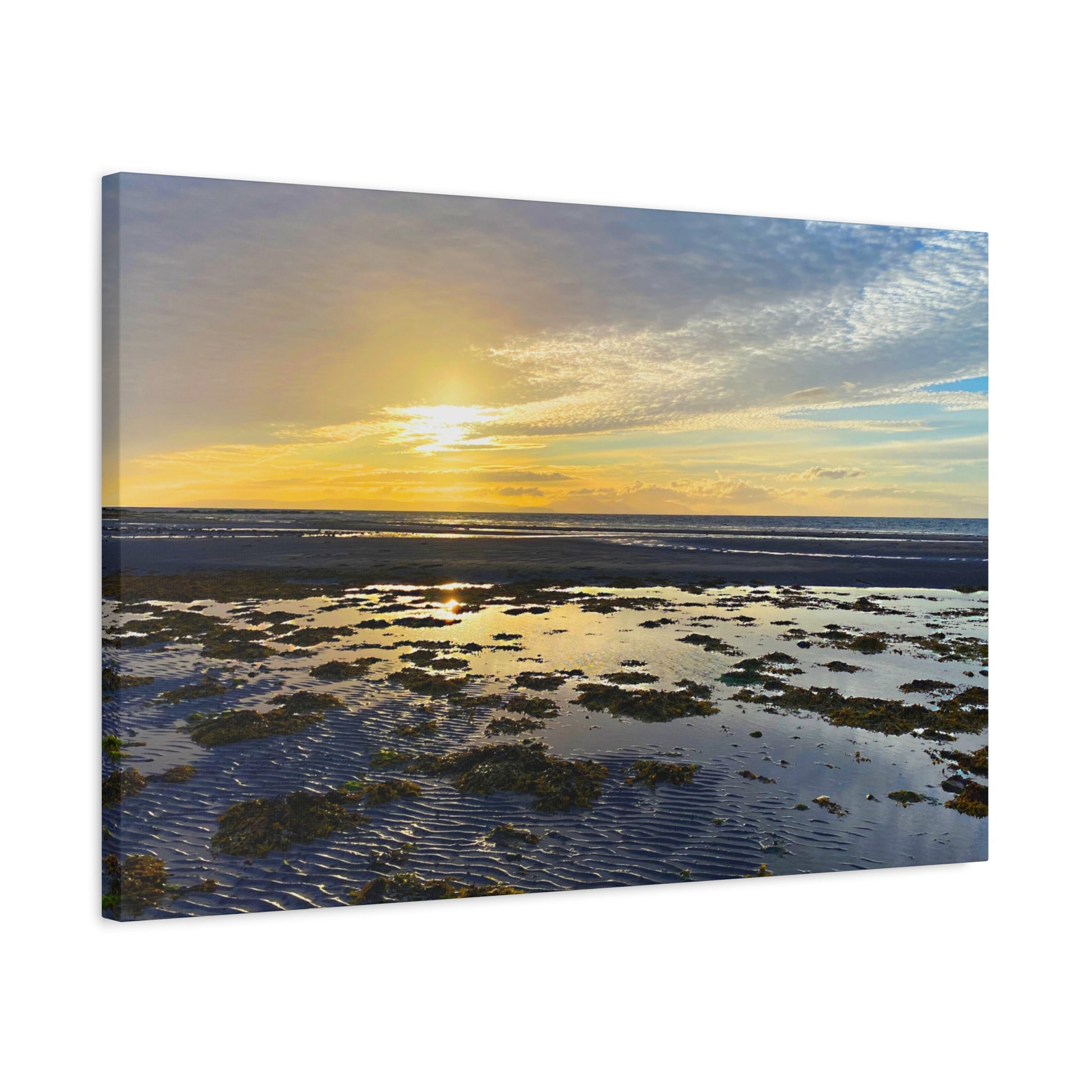 Sunset over a coastal landscape with water and sky.