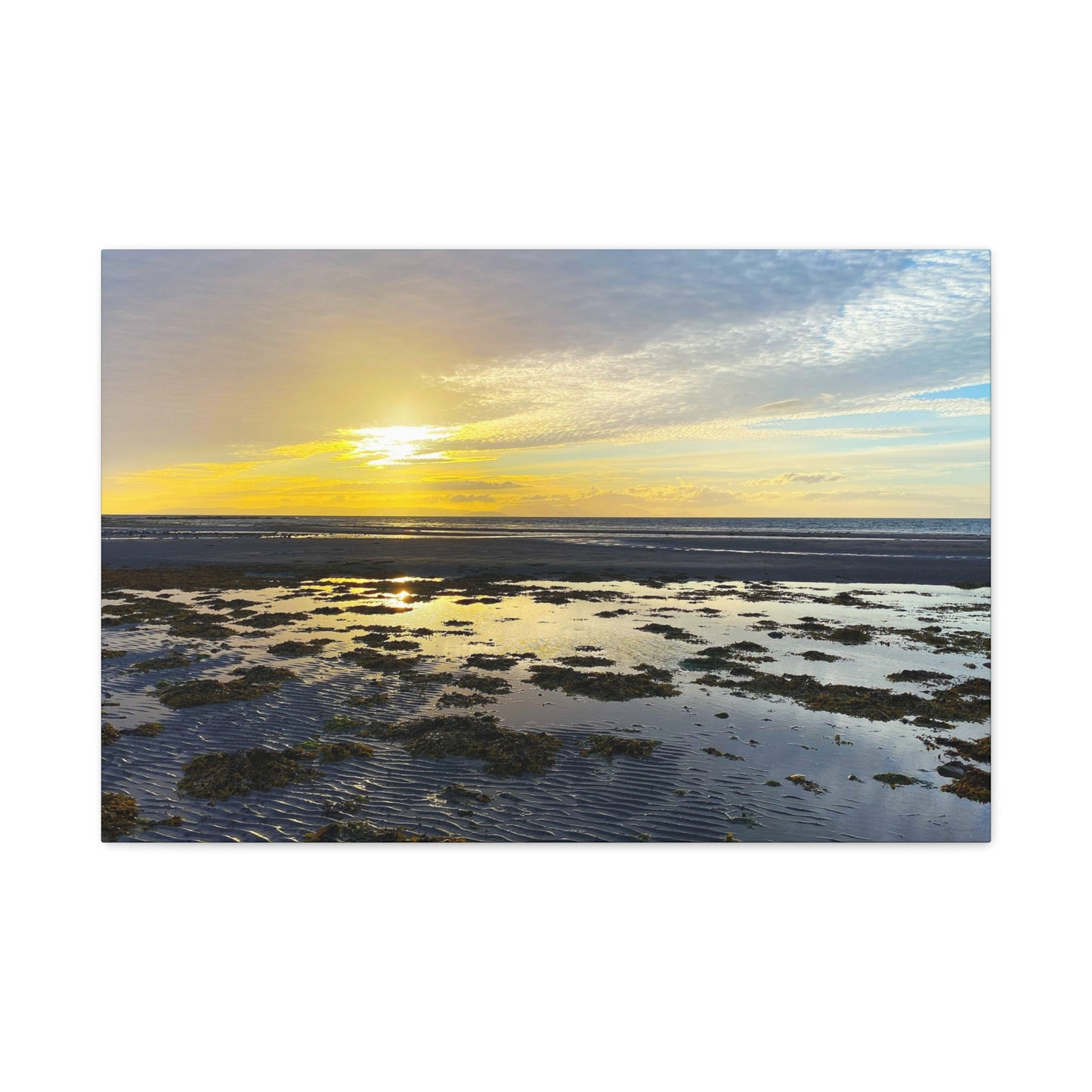 Sunset over a coastal landscape with water and sky.