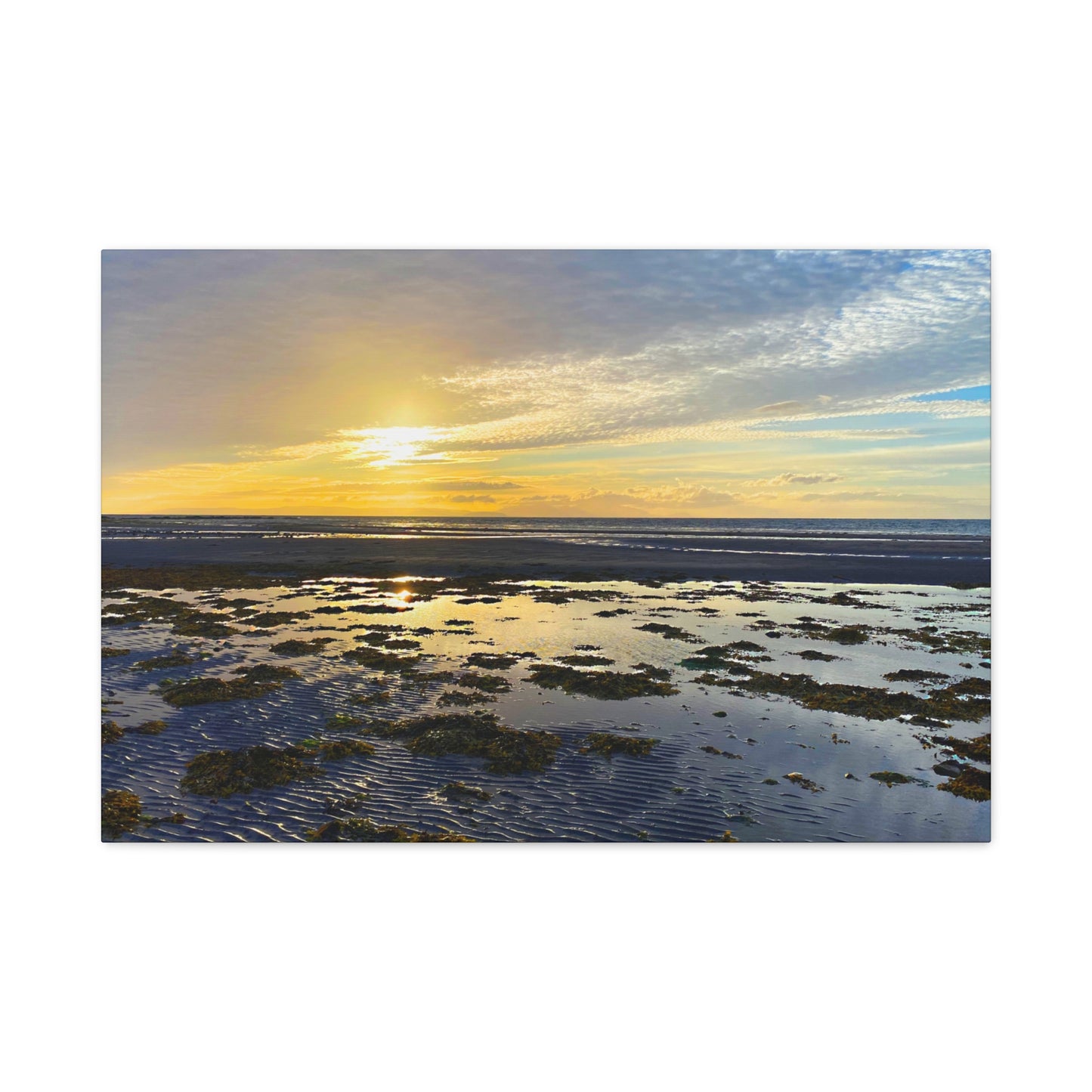 Sunset over a coastal landscape with water and sky.
