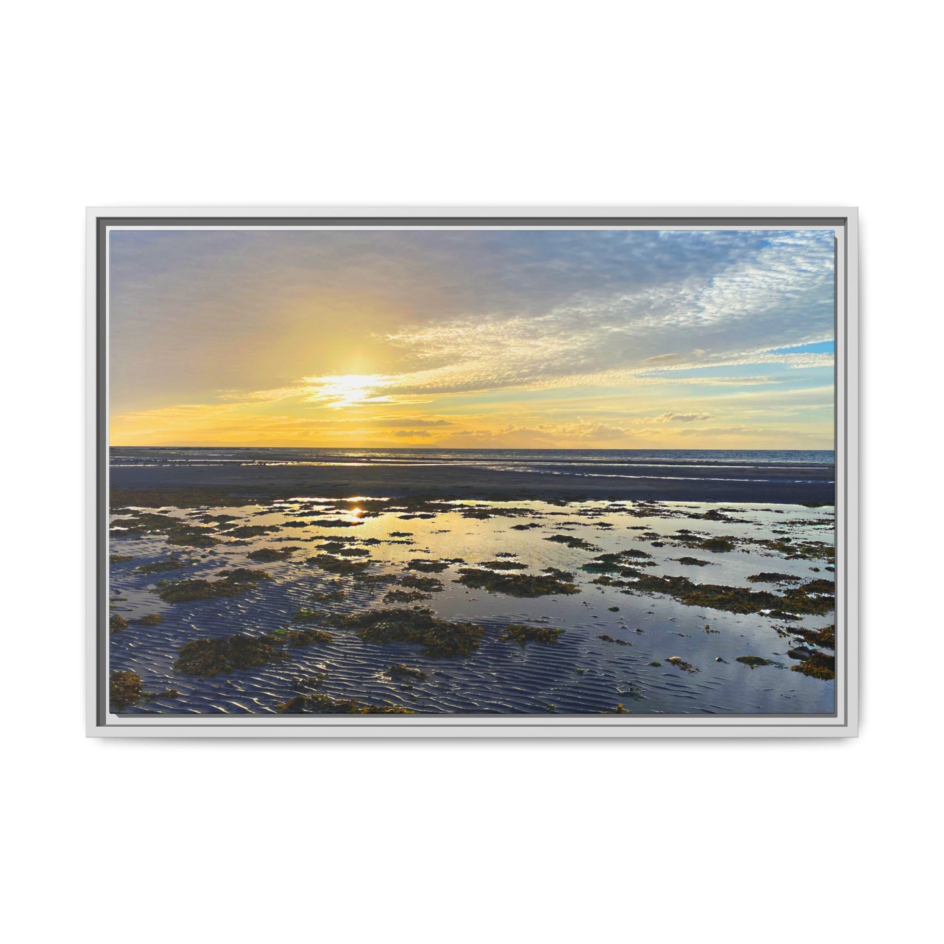 Framed artwork of a sunset over water with a white border