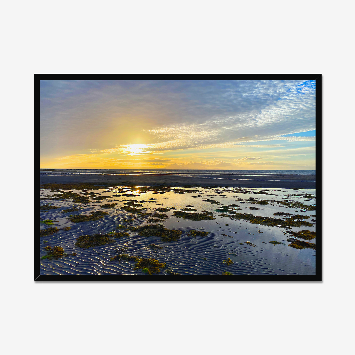 Framed artwork of a beach scene with a sunset sky.
