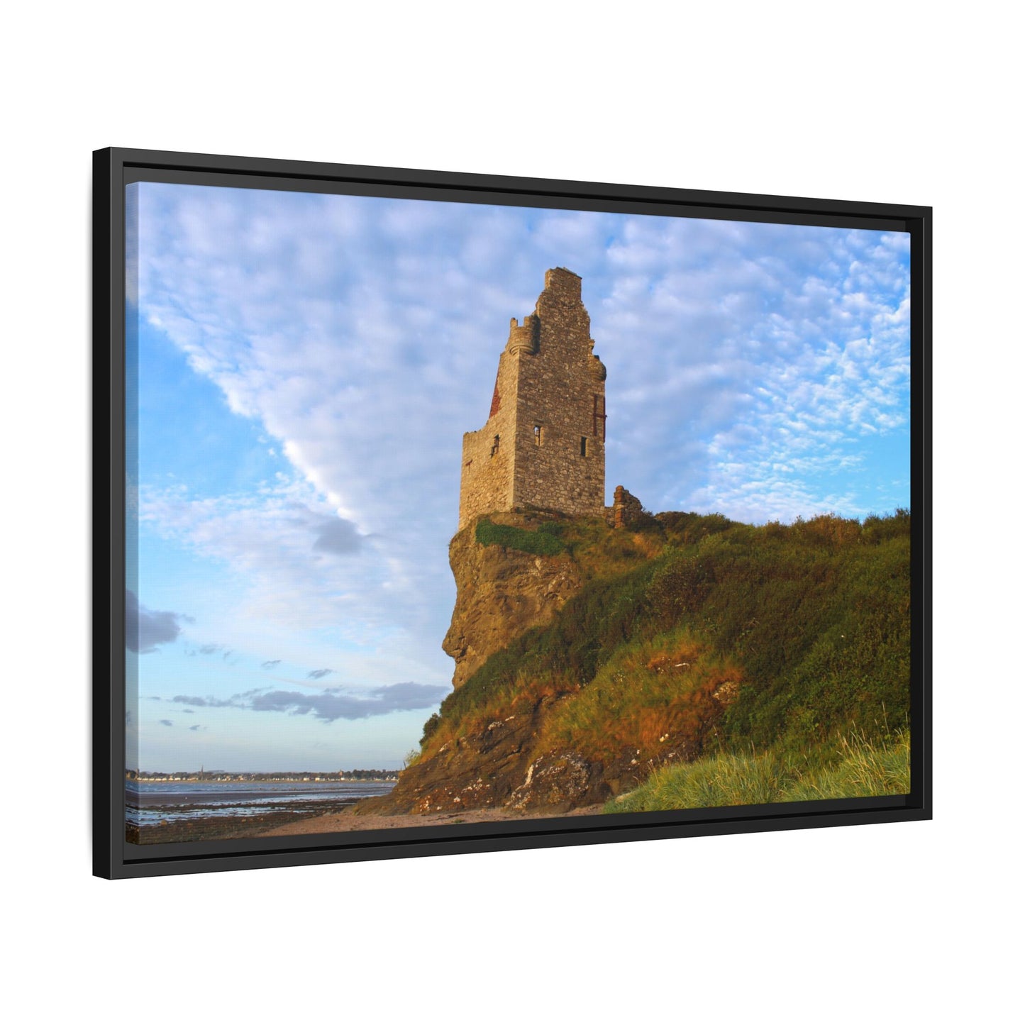 Ruins of a tower on a cliff with a blue sky and clouds, framed as a picture.