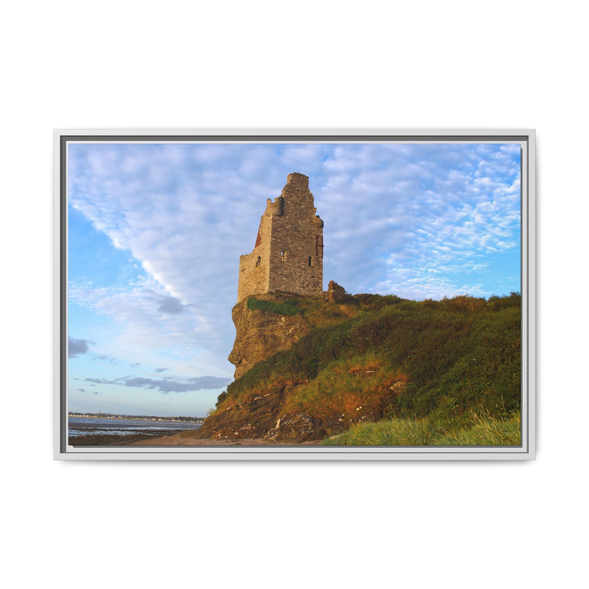 Framed photograph of a stone tower on a cliff with a blue sky.
