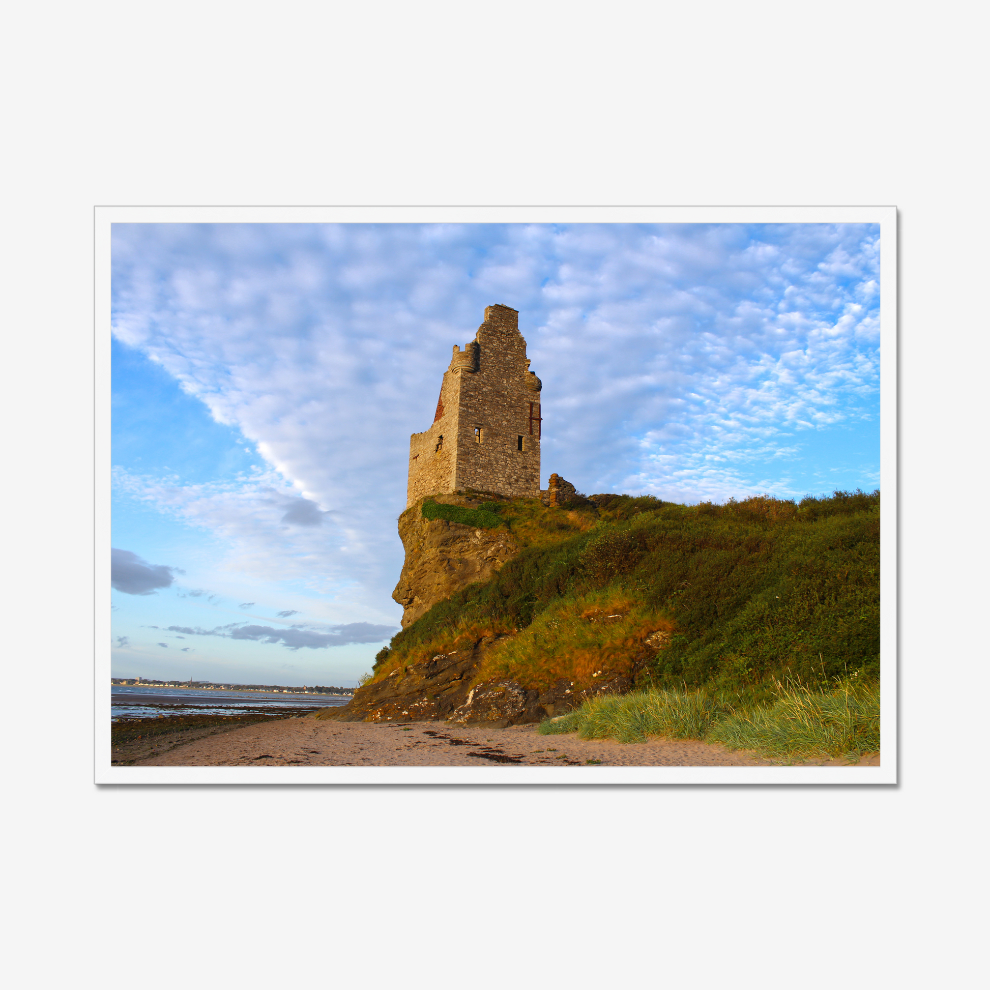 Ruined tower on a cliff with a blue sky and clouds