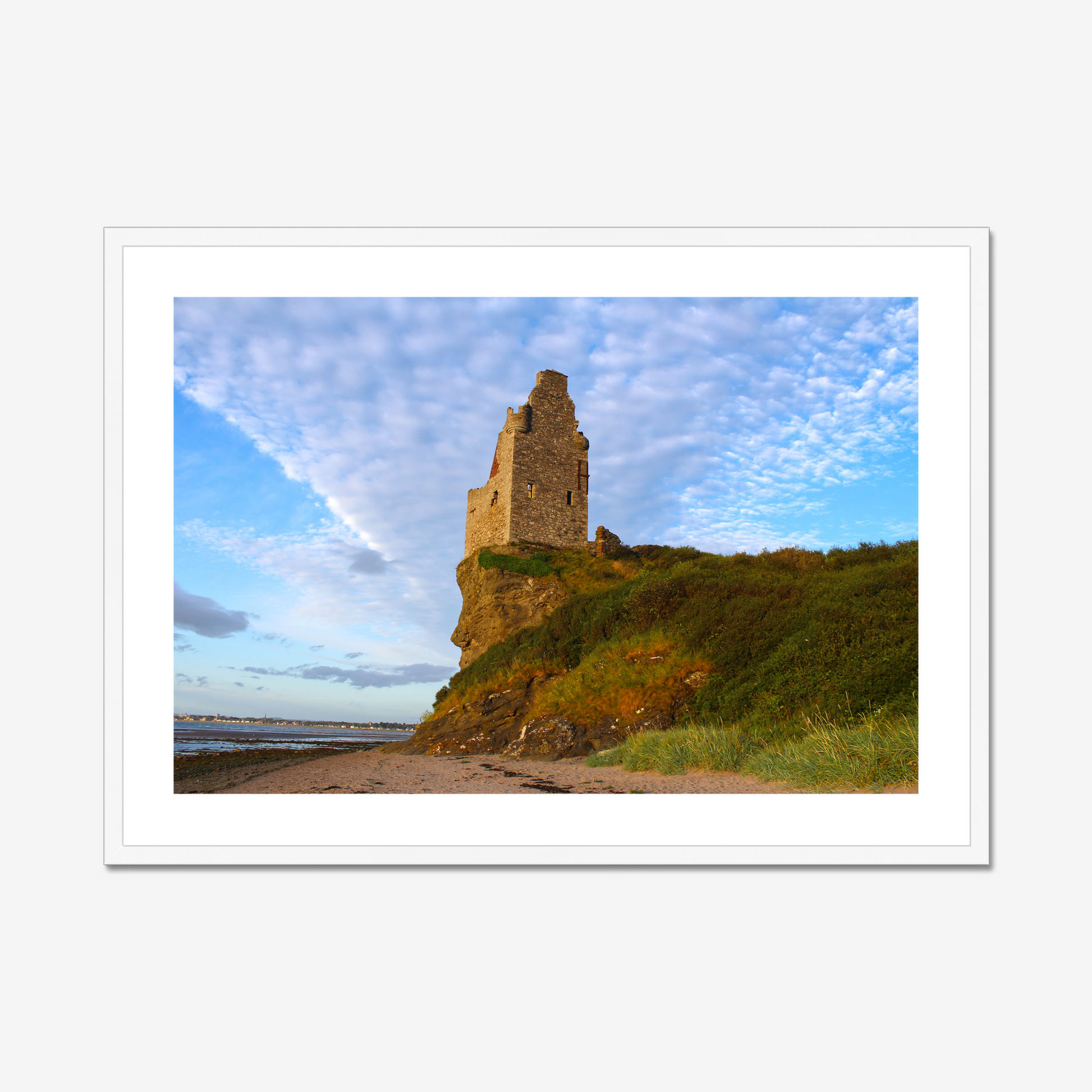 Ruined tower on a cliff with a blue sky and clouds