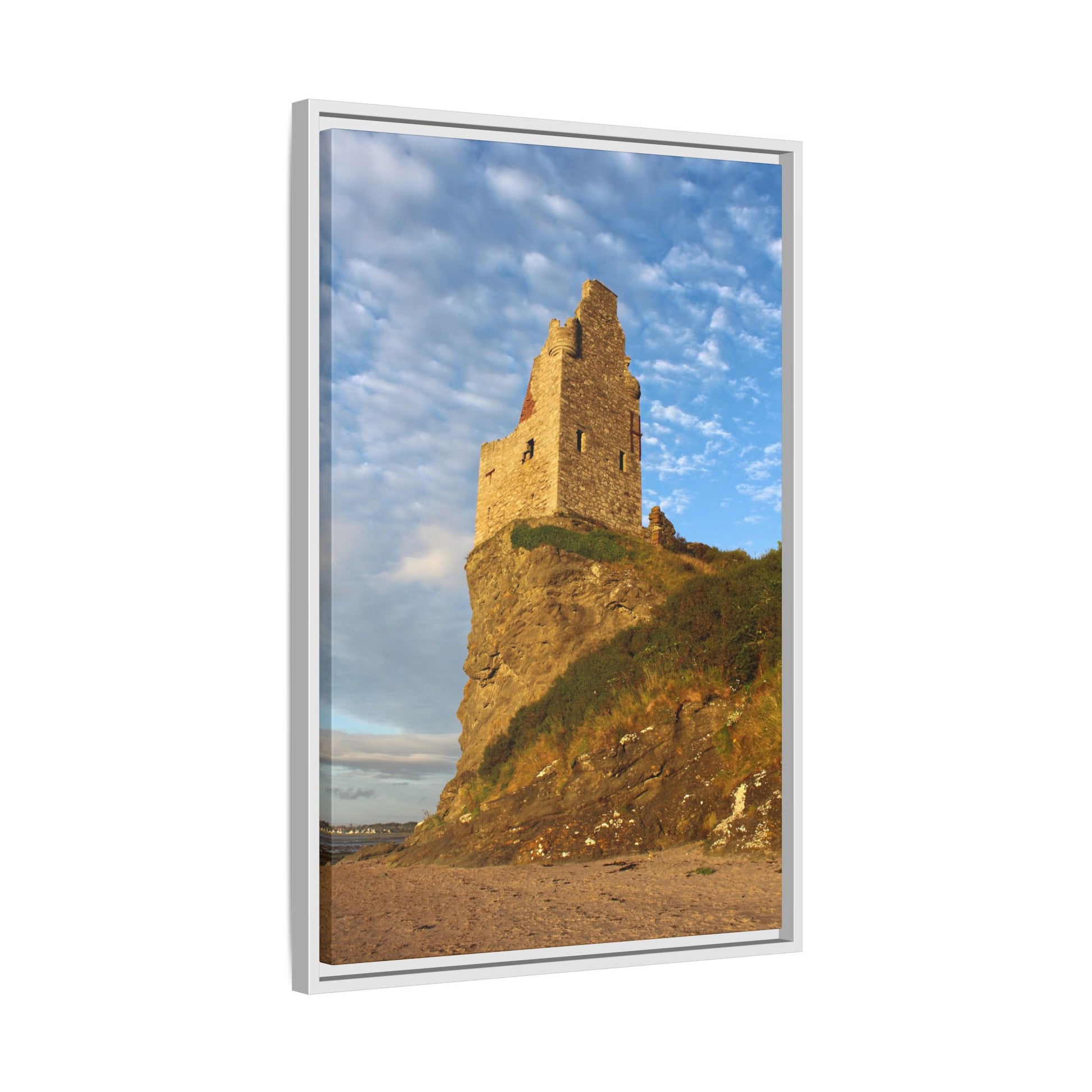 Ruins of a tower on a cliff with a blue sky and clouds in the background