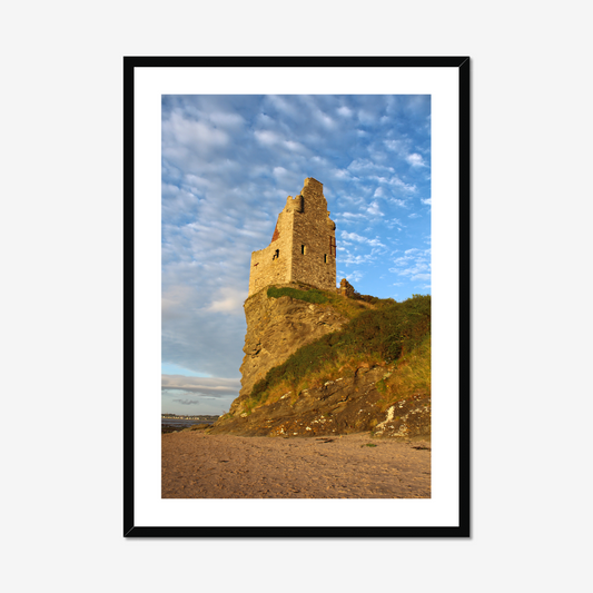 Framed photograph of a castle tower on a cliff with a blue sky.