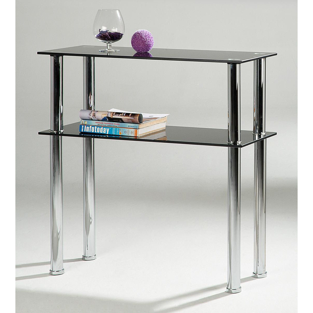 A console table with black glass shelves and silver legs