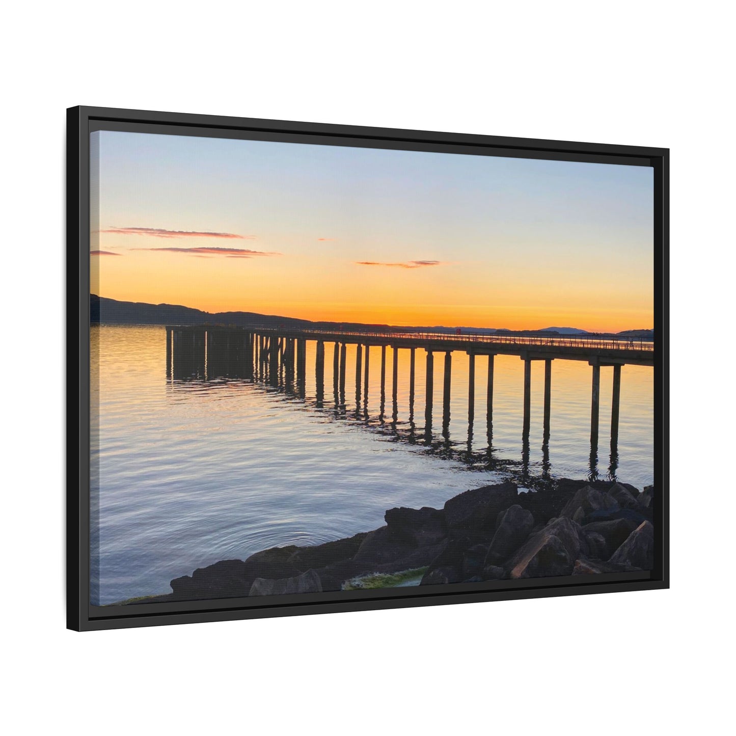 Framed artwork of a sunset over a dock with mountains in the background.