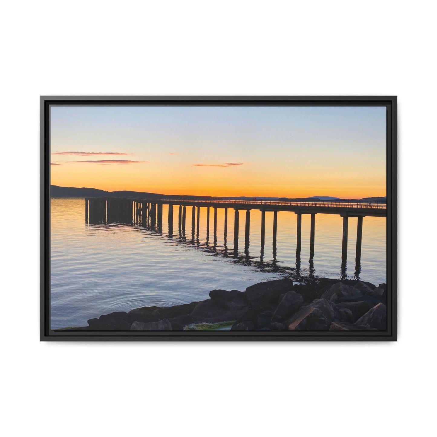 Framed photograph of a sunset over a dock with a black frame.