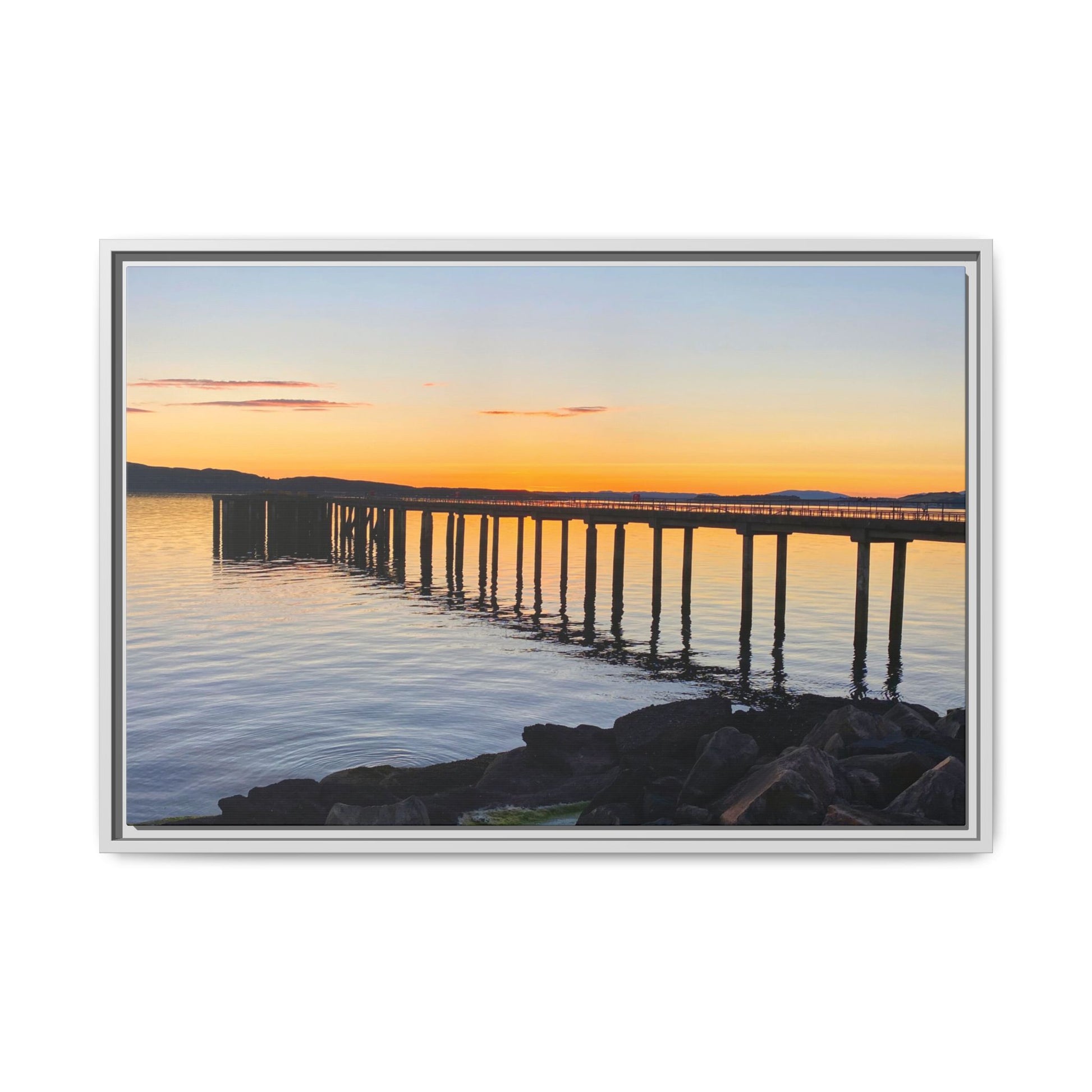Framed photograph of a sunset over a dock with a white border
