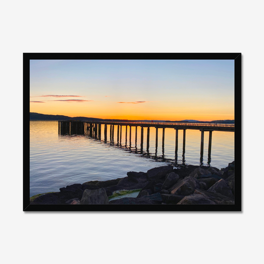 Framed artwork of a sunset over a dock with a black border