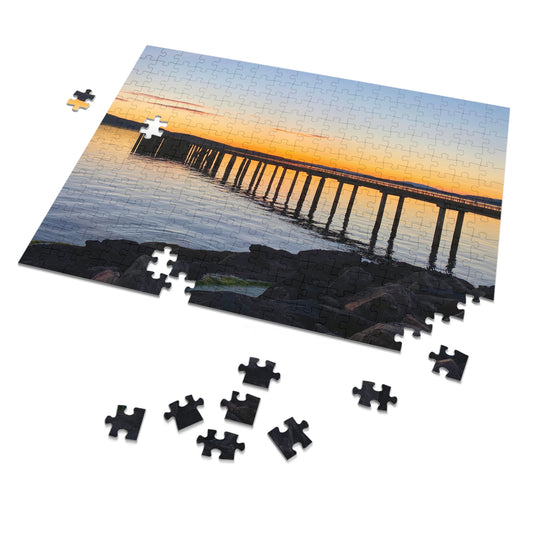 Jigsaw puzzle with a sunset over a bridge scene, some pieces missing.