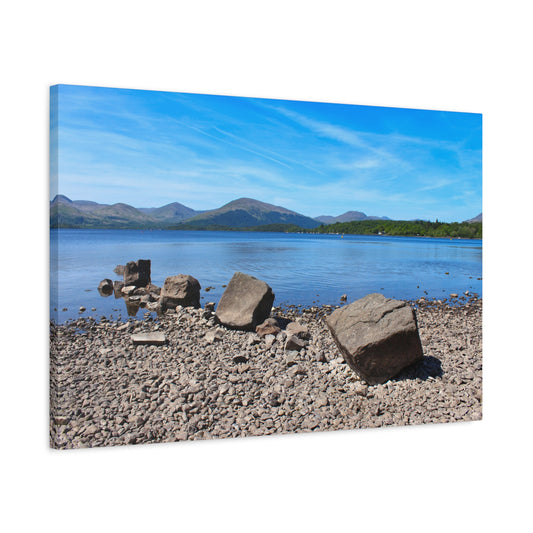 Scenic view of a lake with rocks and mountains on a clear day