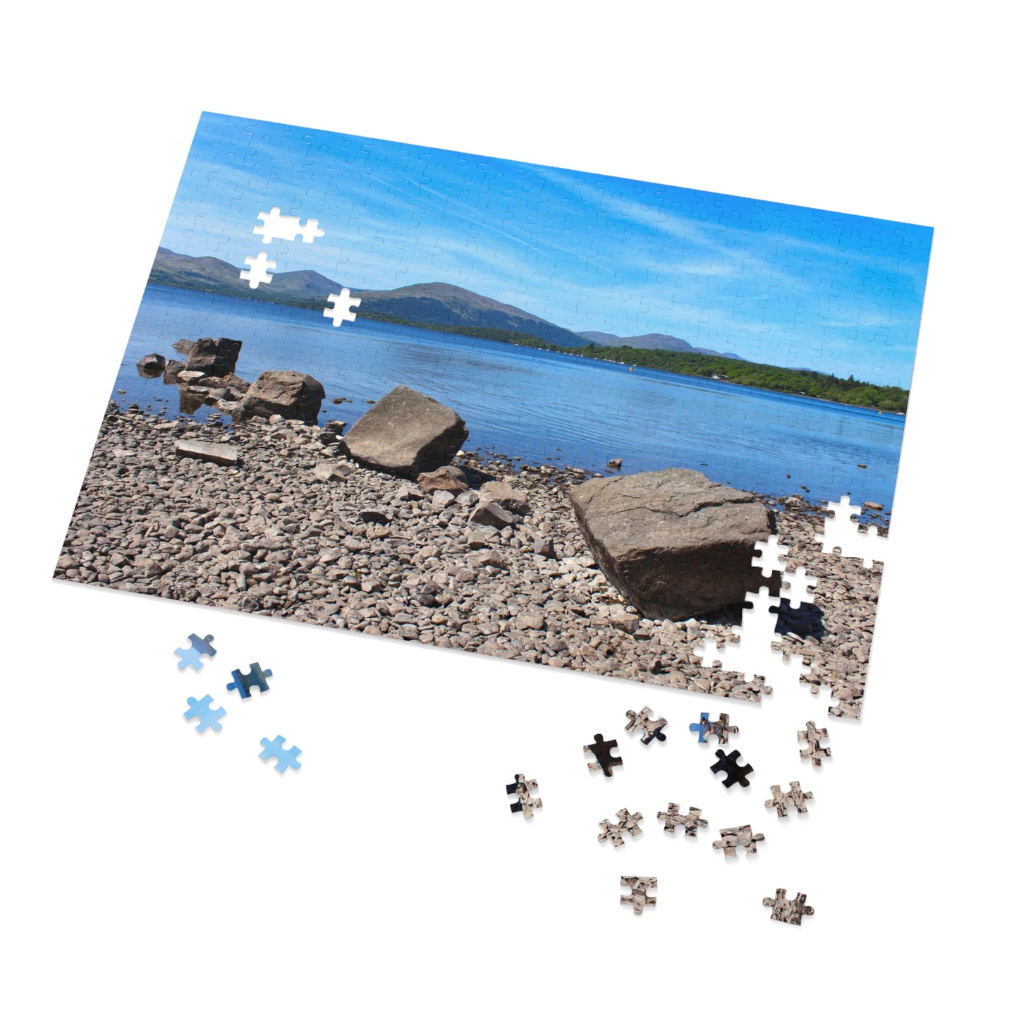 Jigsaw puzzle with a scenic view of a lake and mountains on a white background