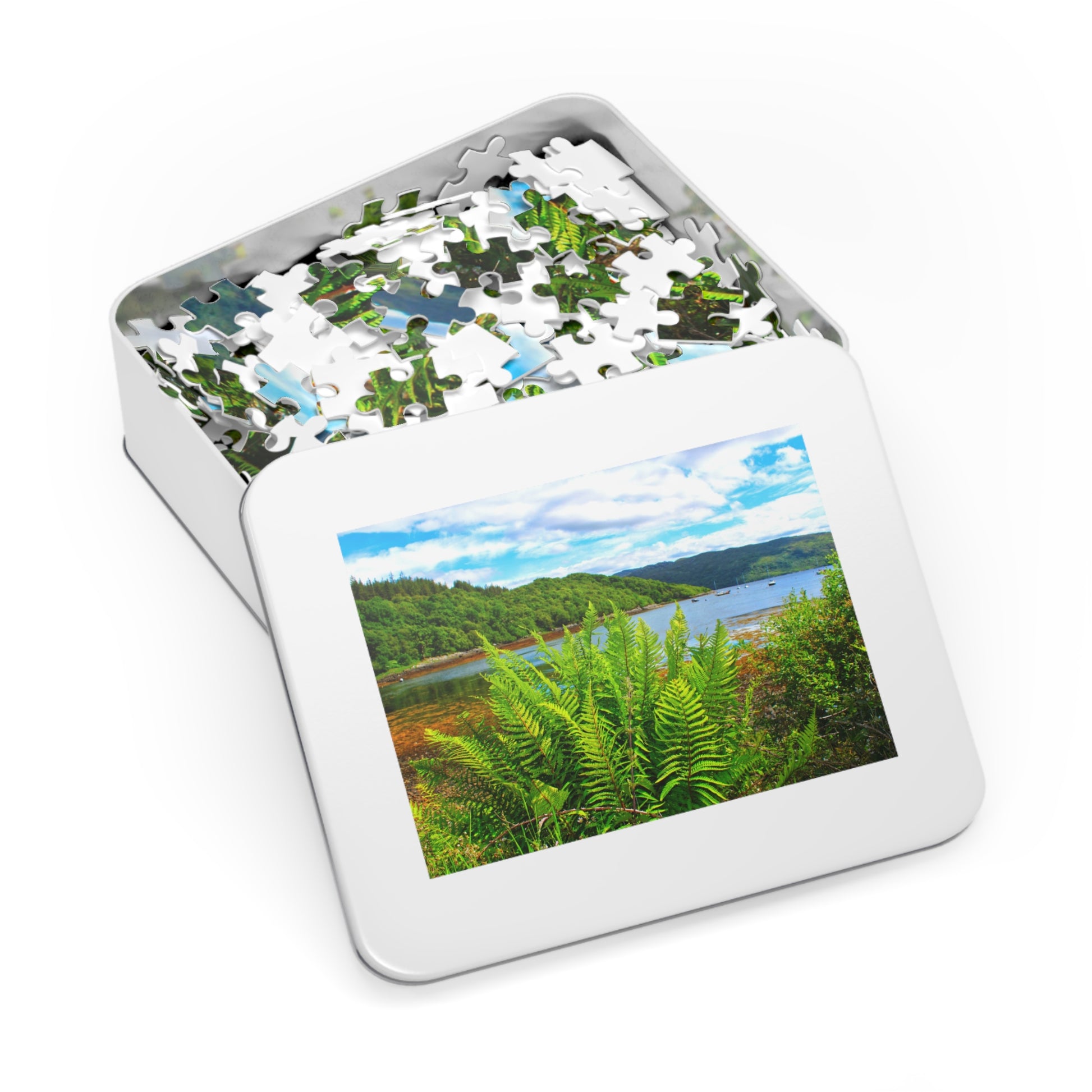 Jigsaw puzzle in a tin with a scenic view of a lake and forest on the cover