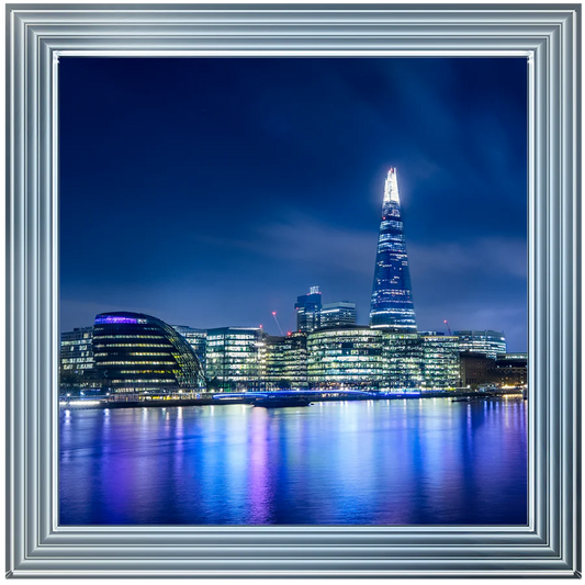 Silver framed picture of the London Shard at night with a blue sky.