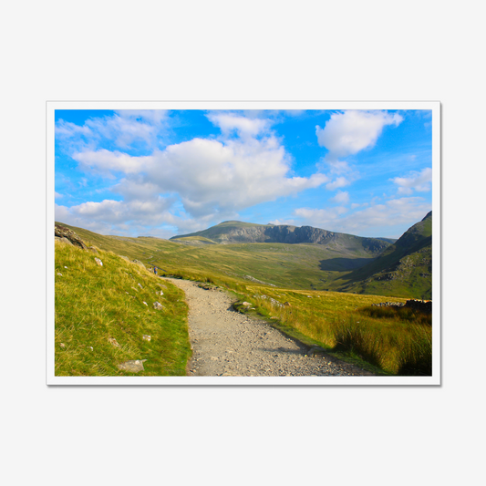 Scenic view of a mountain landscape with a clear blue sky and a path leading towards the mountains.