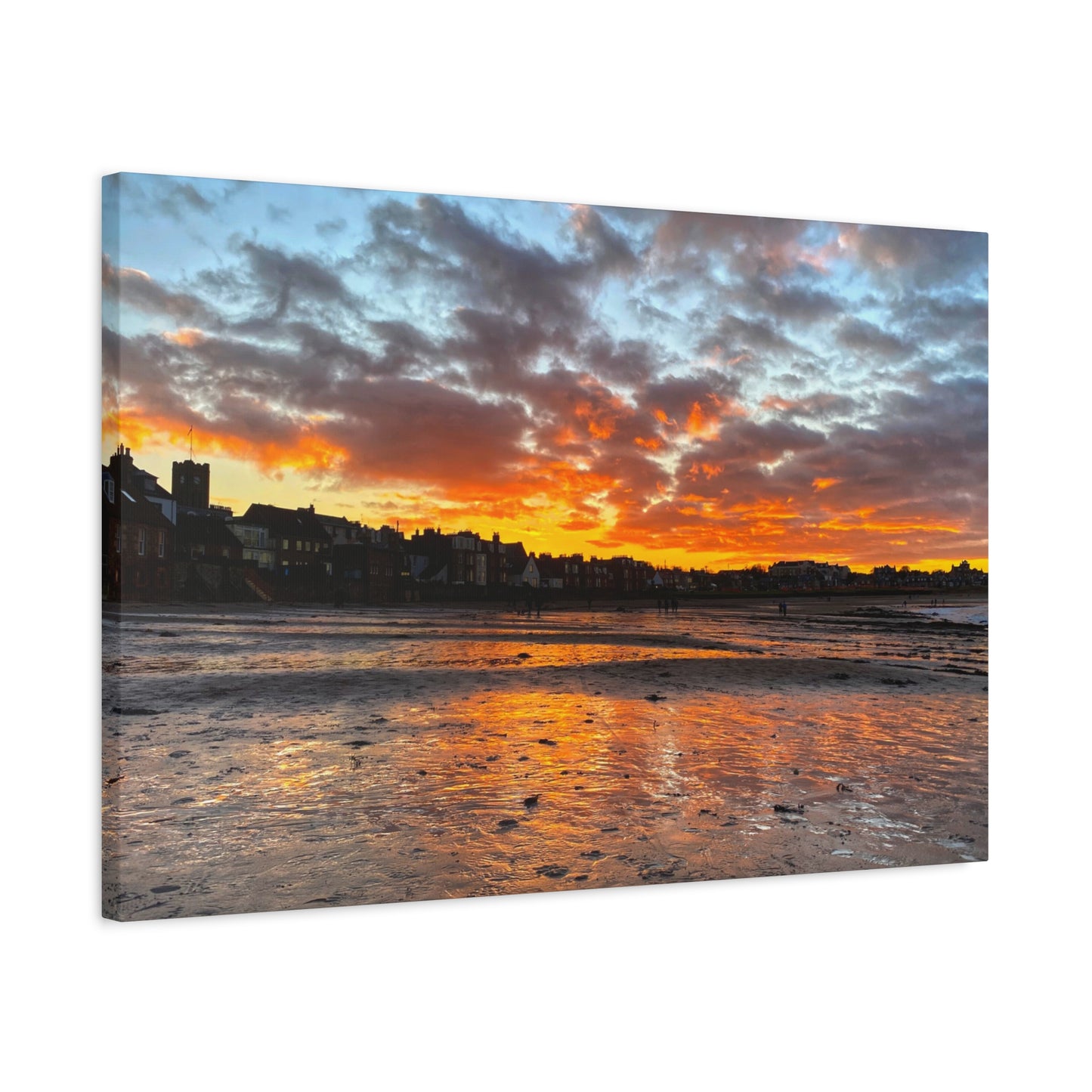 Sunset over a coastal town with vibrant colors reflected in the water.