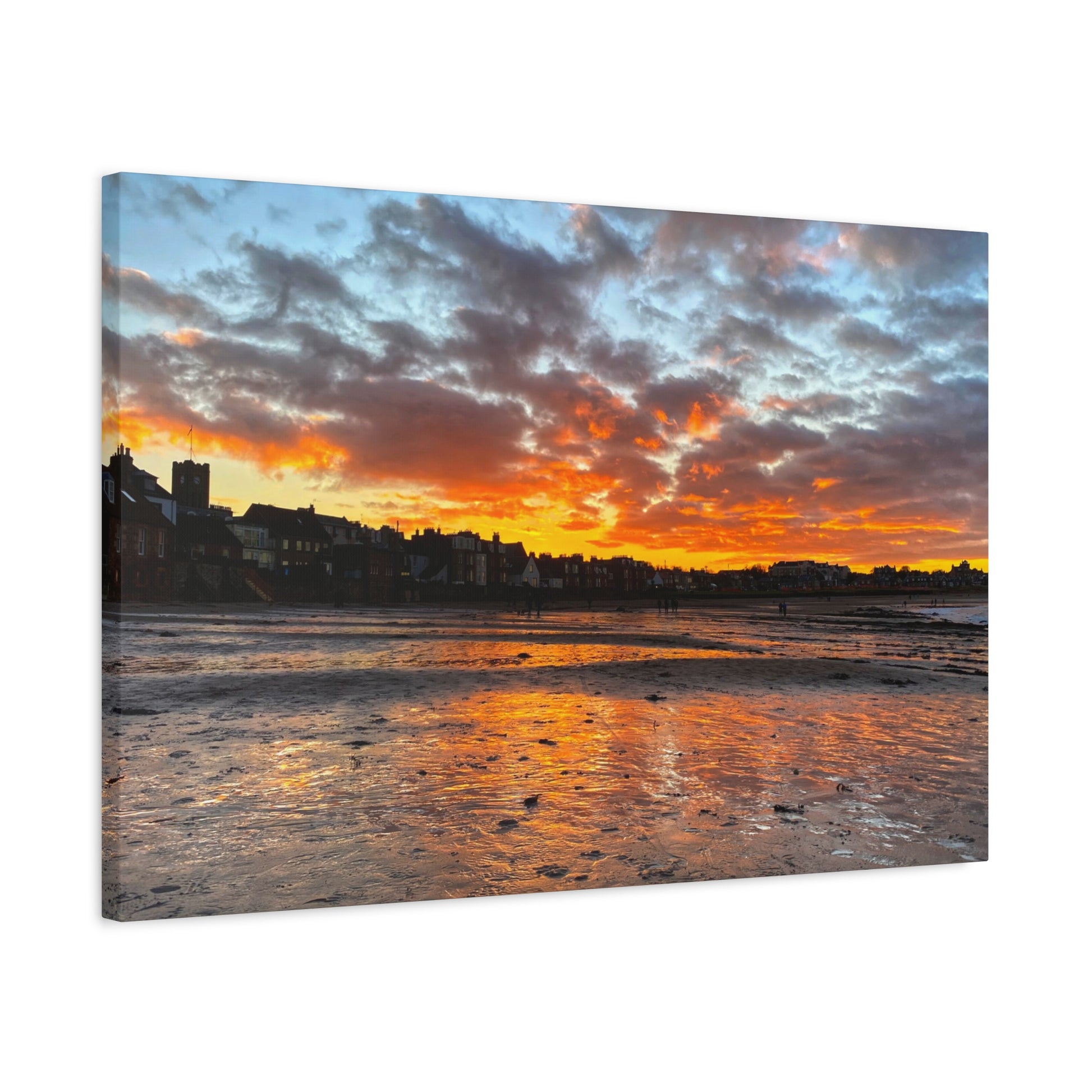 Sunset over a coastal town with vibrant colors reflected in the water.