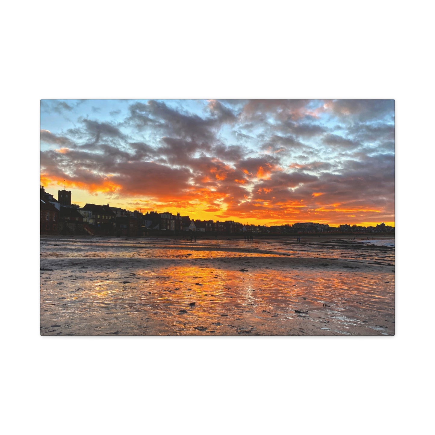 Sunset over a coastal town with vibrant orange and blue sky.