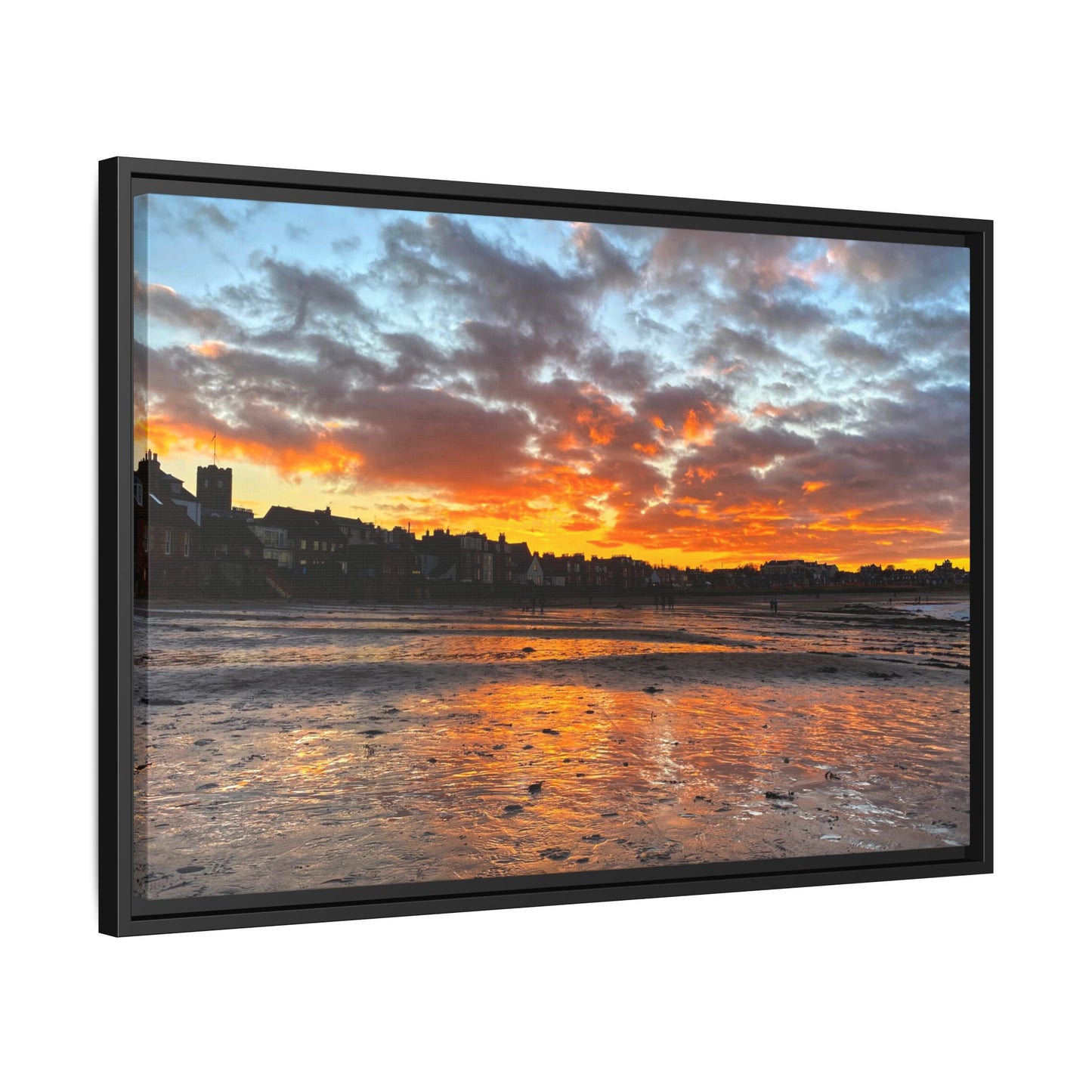 Framed artwork of a sunset over a coastal town with vibrant colors.