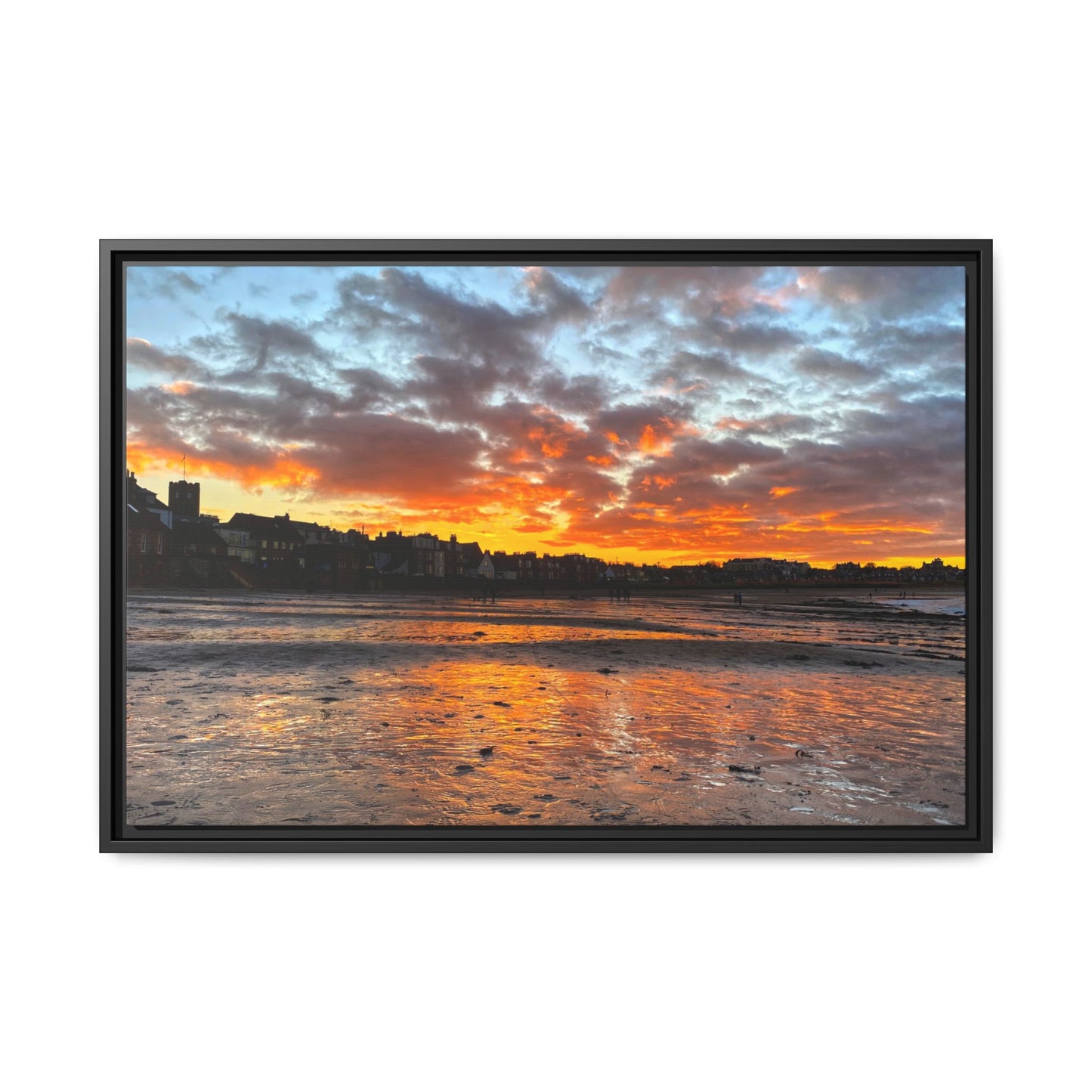 Framed artwork of a sunset over a coastal town with vibrant colors.