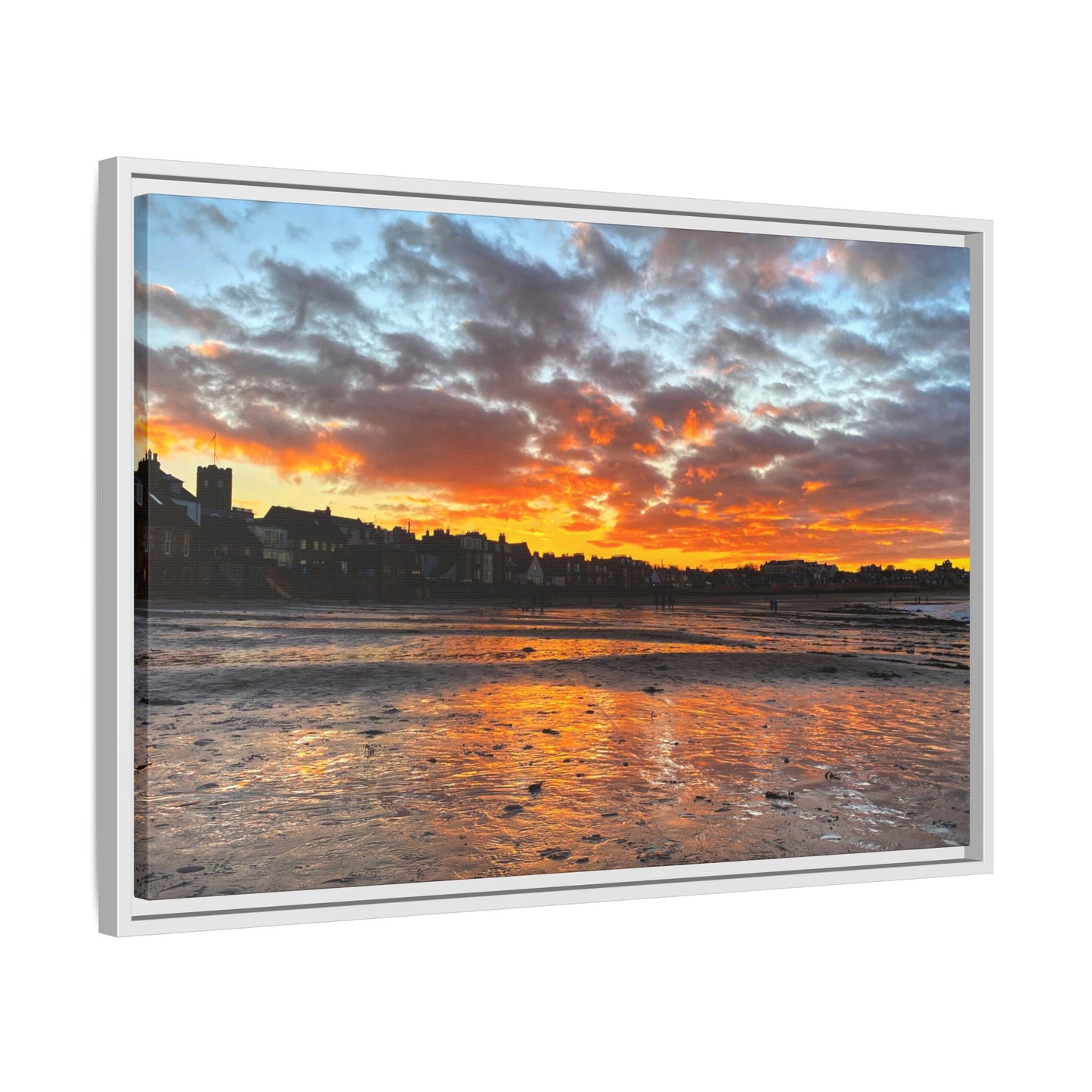 Framed artwork of a sunset over a coastal town with vibrant colors.