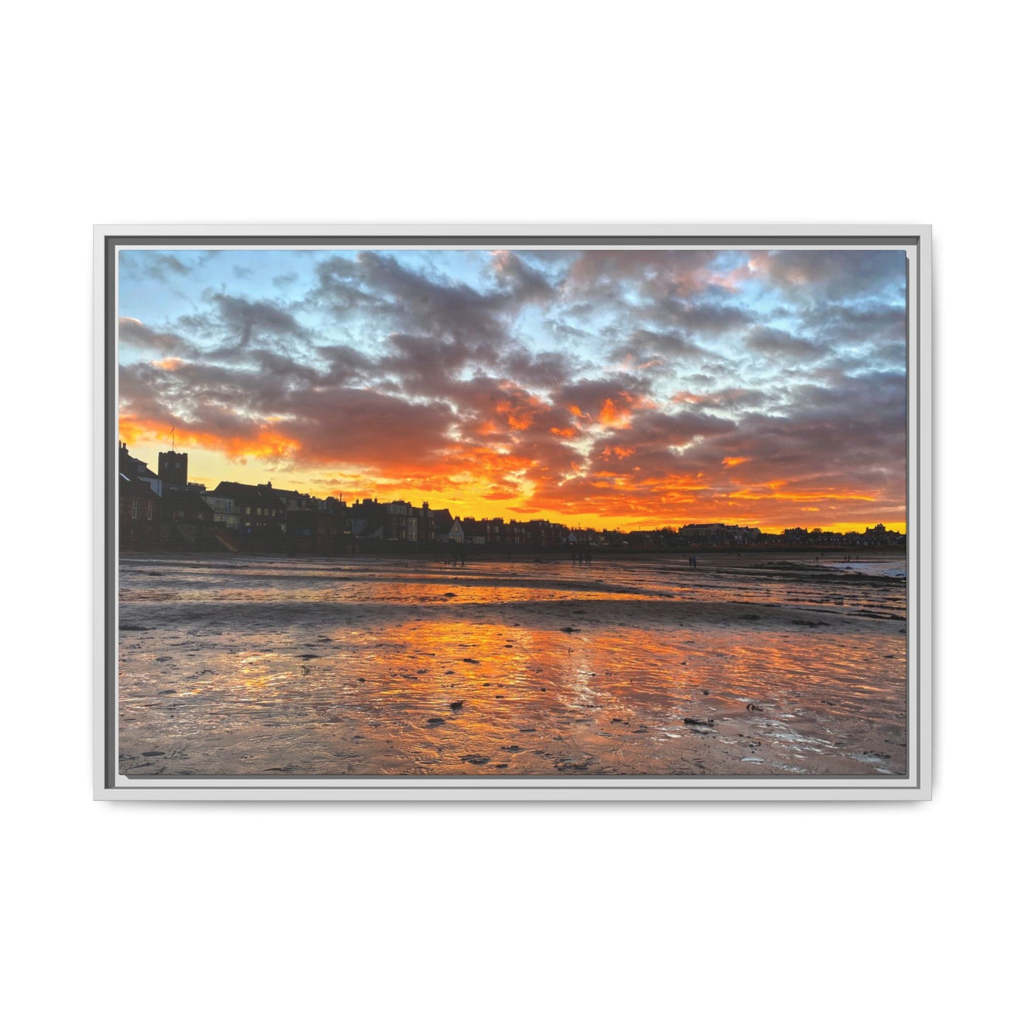 Framed artwork of a sunset over a coastal town with vibrant colors.