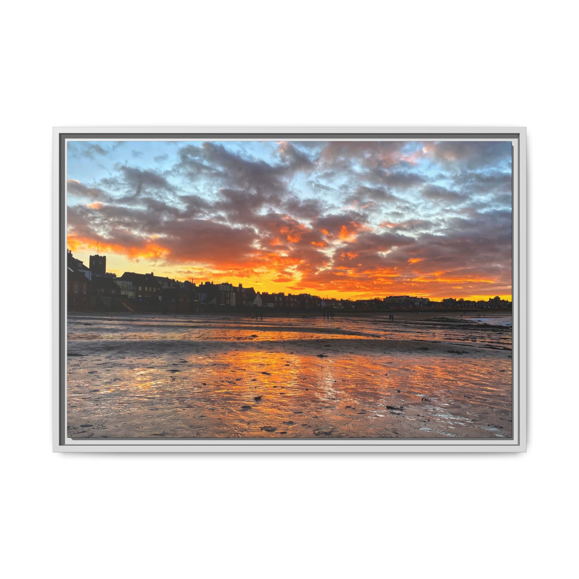 Framed artwork of a sunset over a coastal town with vibrant colors.