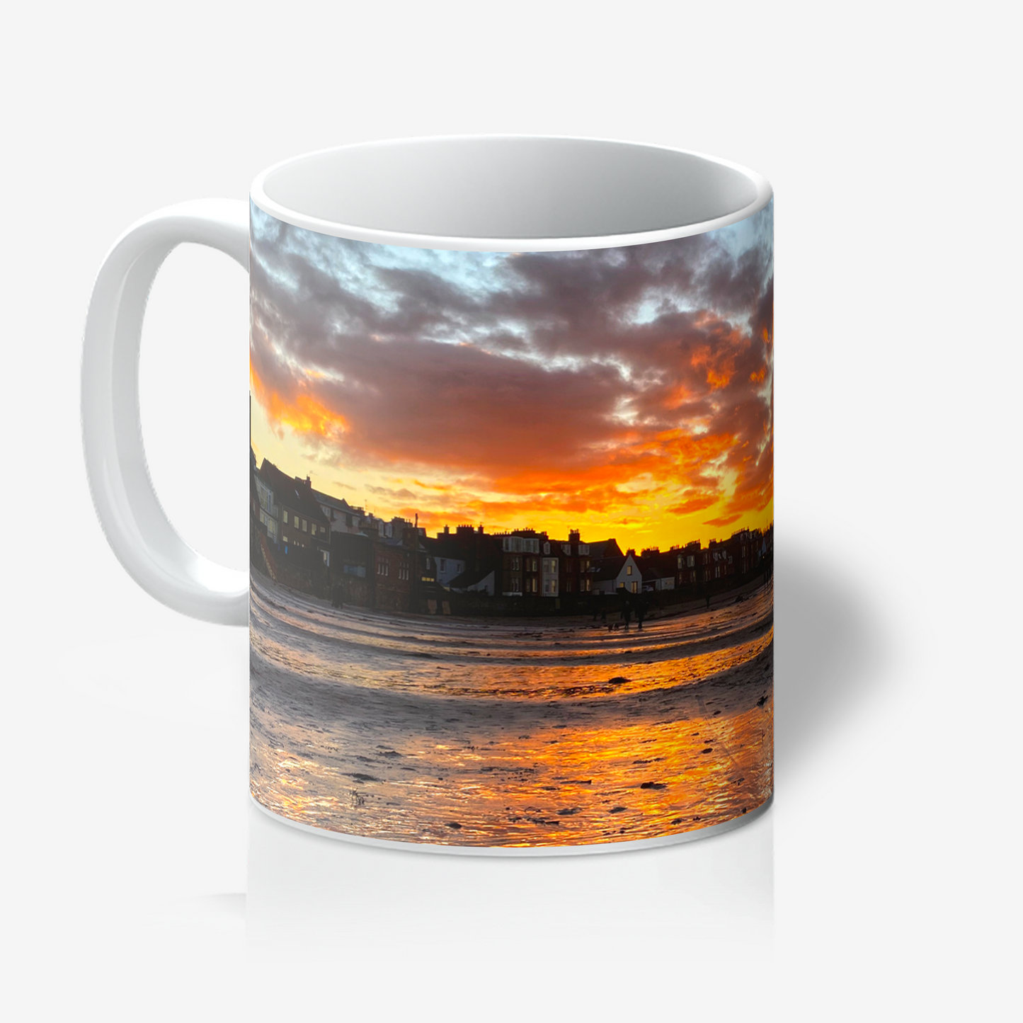 Mug with a sunset over a coastal town design on a white background