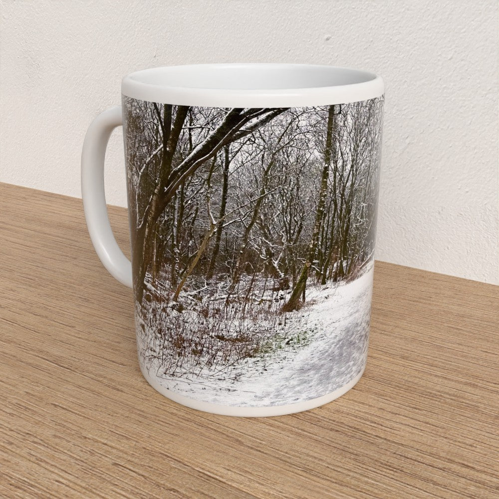 Mug with a winter forest design on a wooden surface